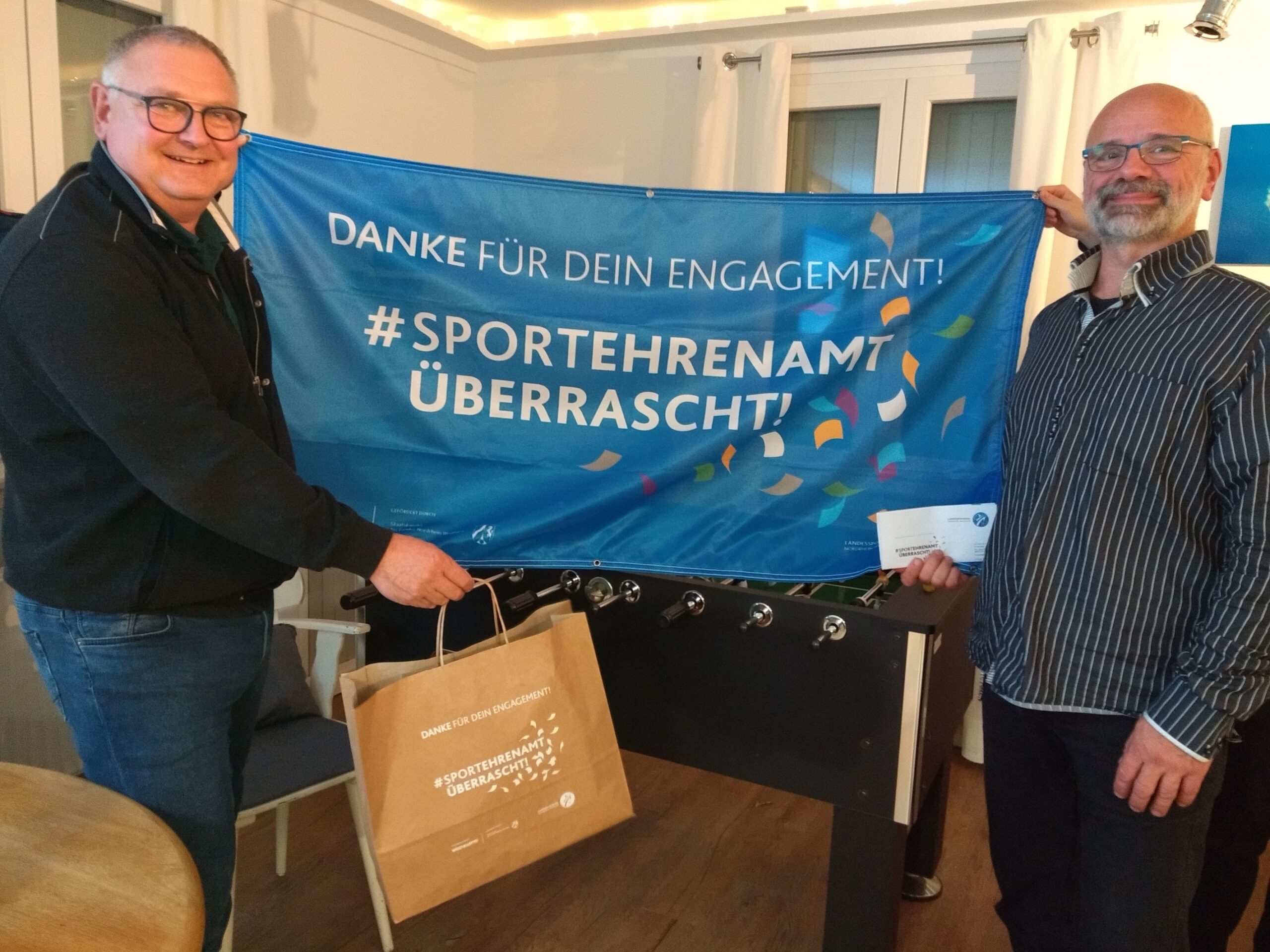 Georg Proske überreicht Odo Lütje die Überraschung vom Landessportbund